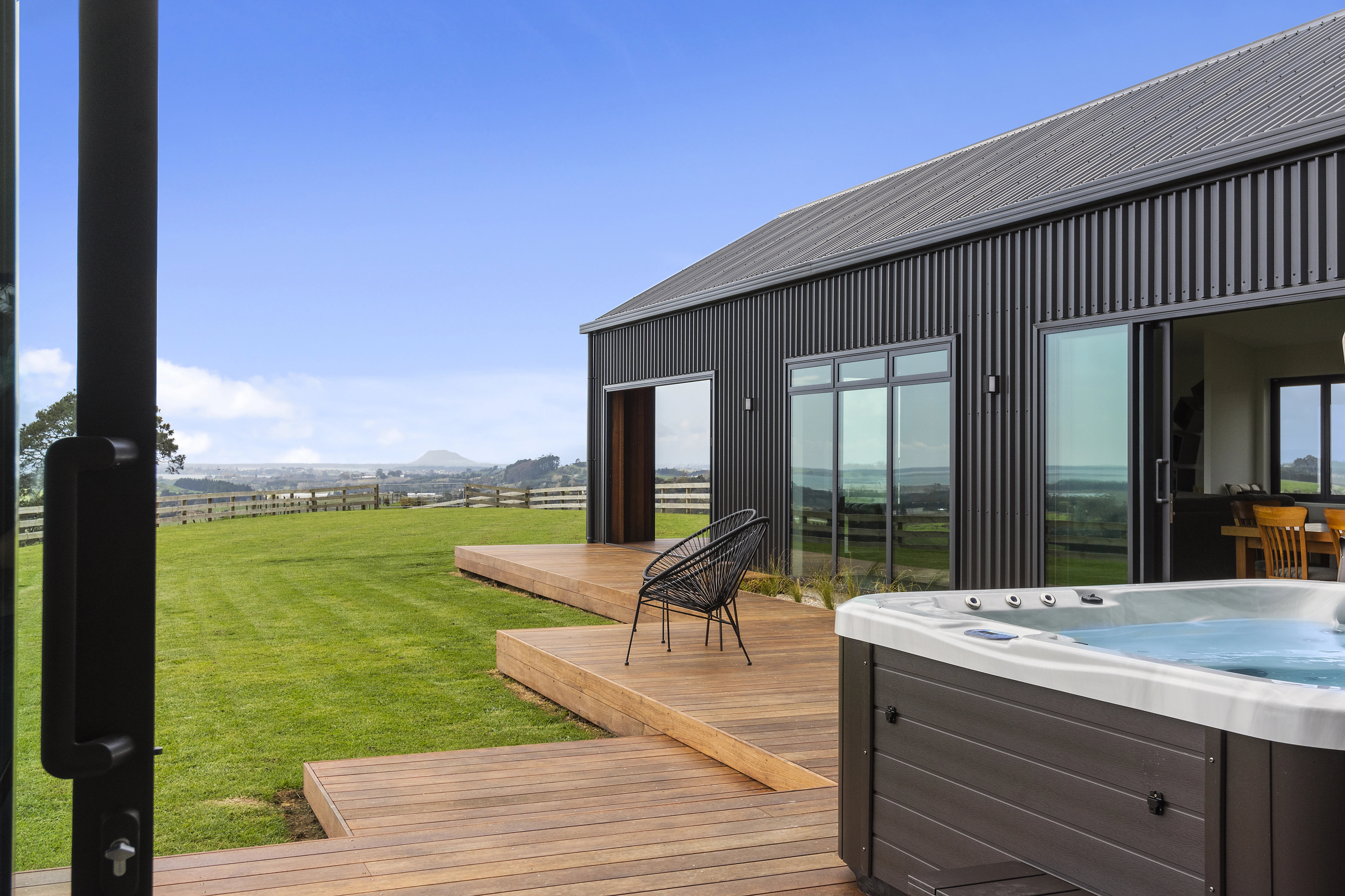 A rural property that has new cladding, a new roof, and a new deck and with a large front lawn