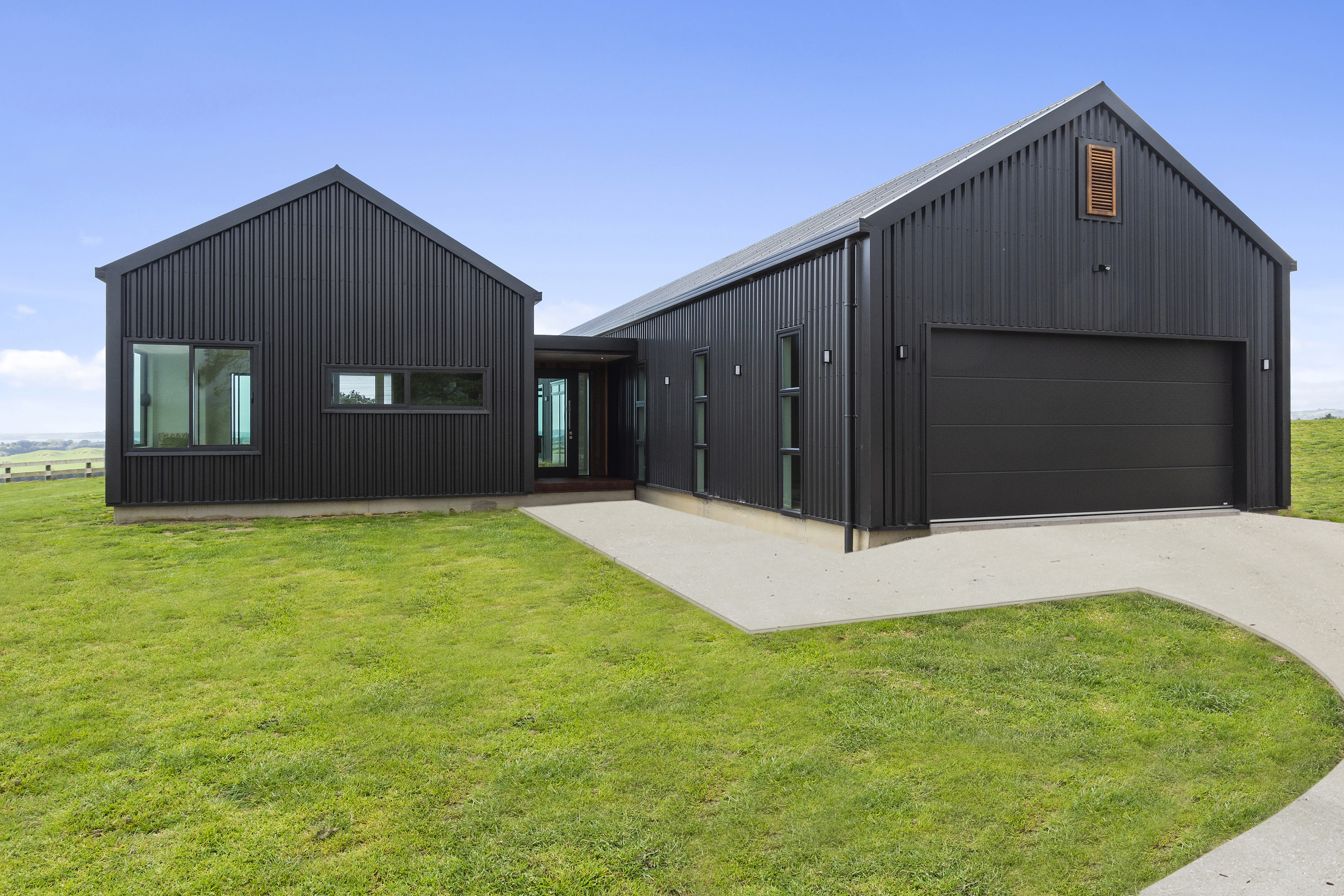 2 modern houses with new roof installed, with a white driveway and green landscapepe