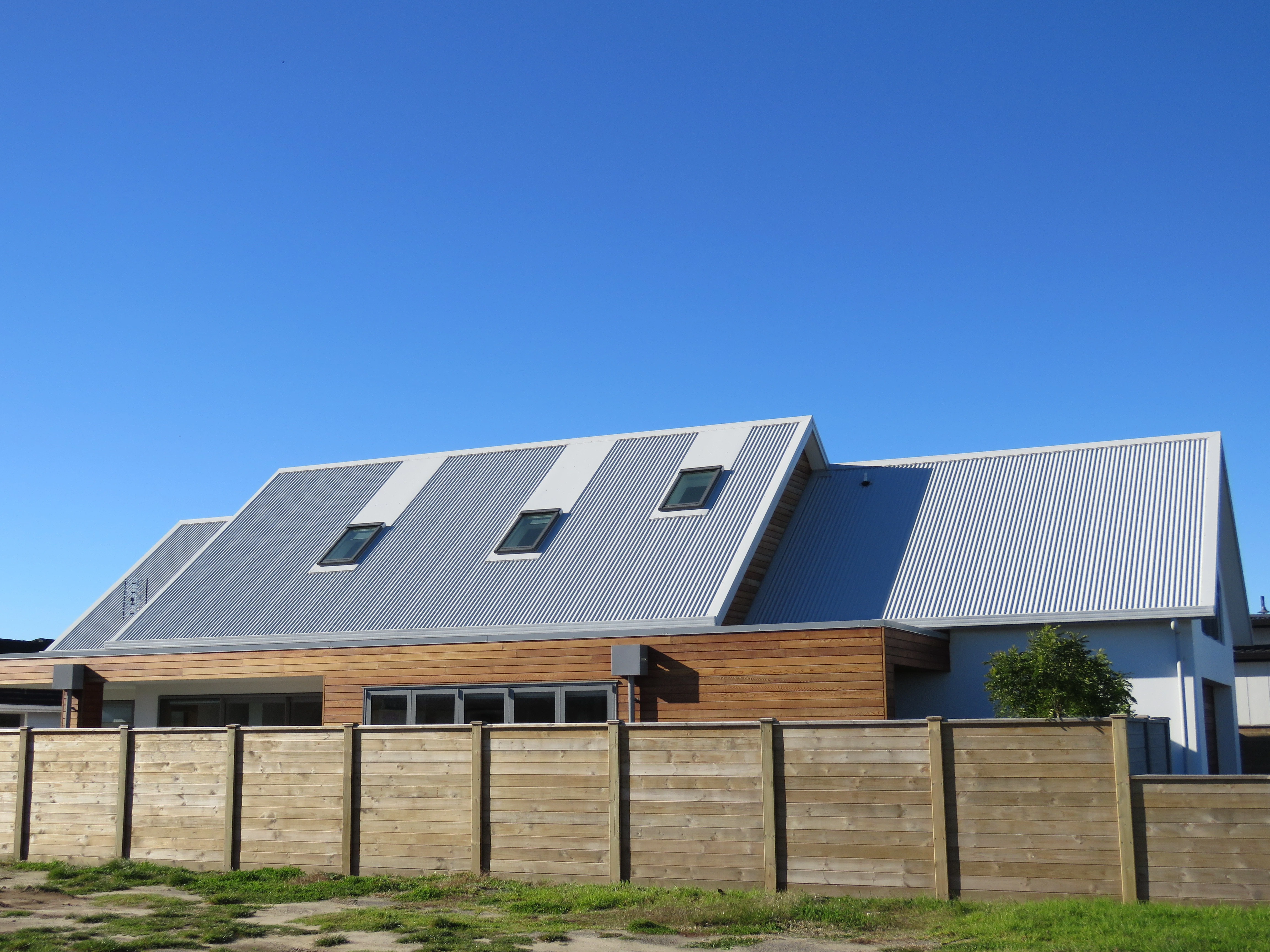 A new home with a new roof and a fence on the edge of the property boundary