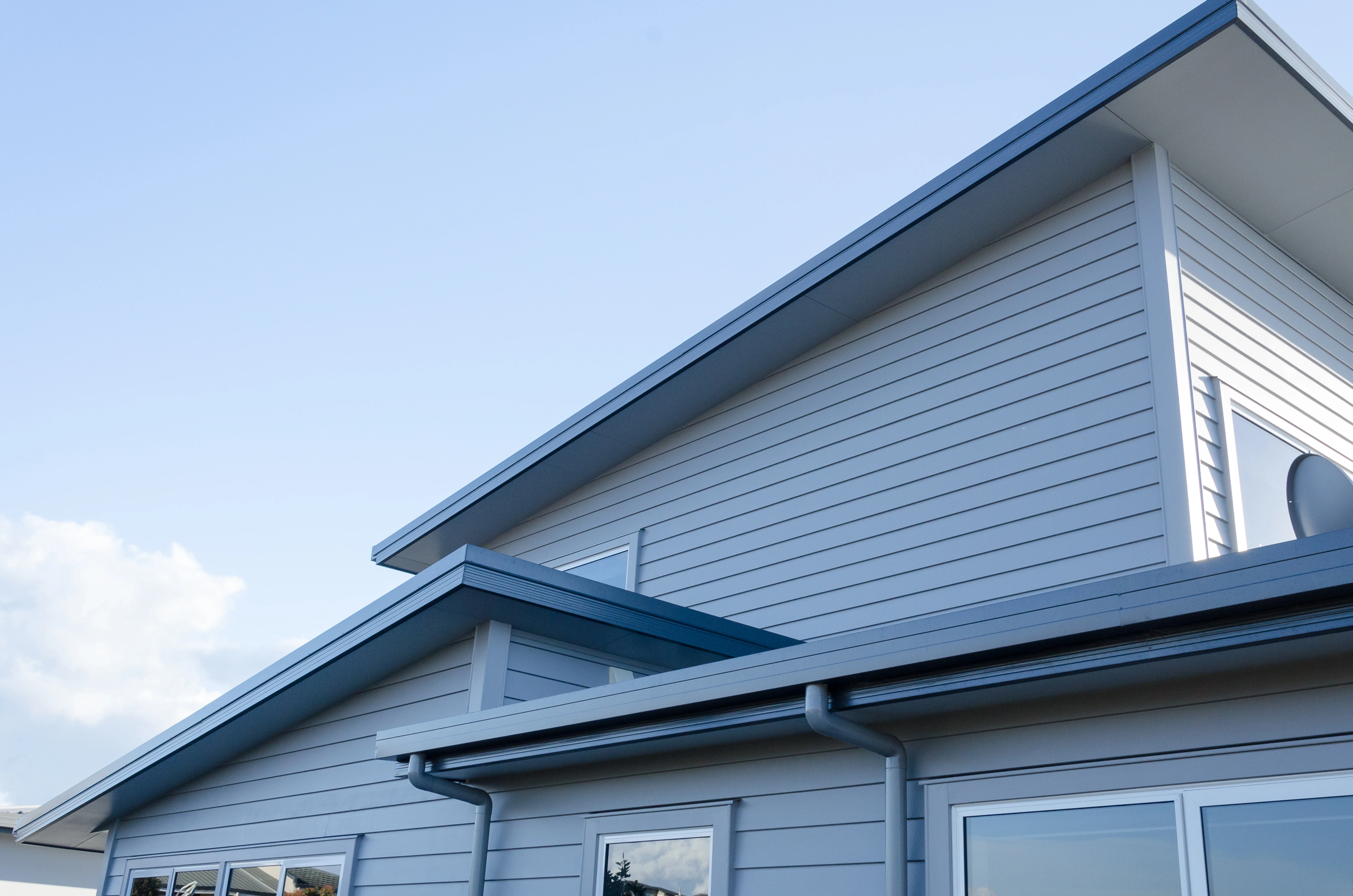 The side of a new home with three levels of a new roof in view