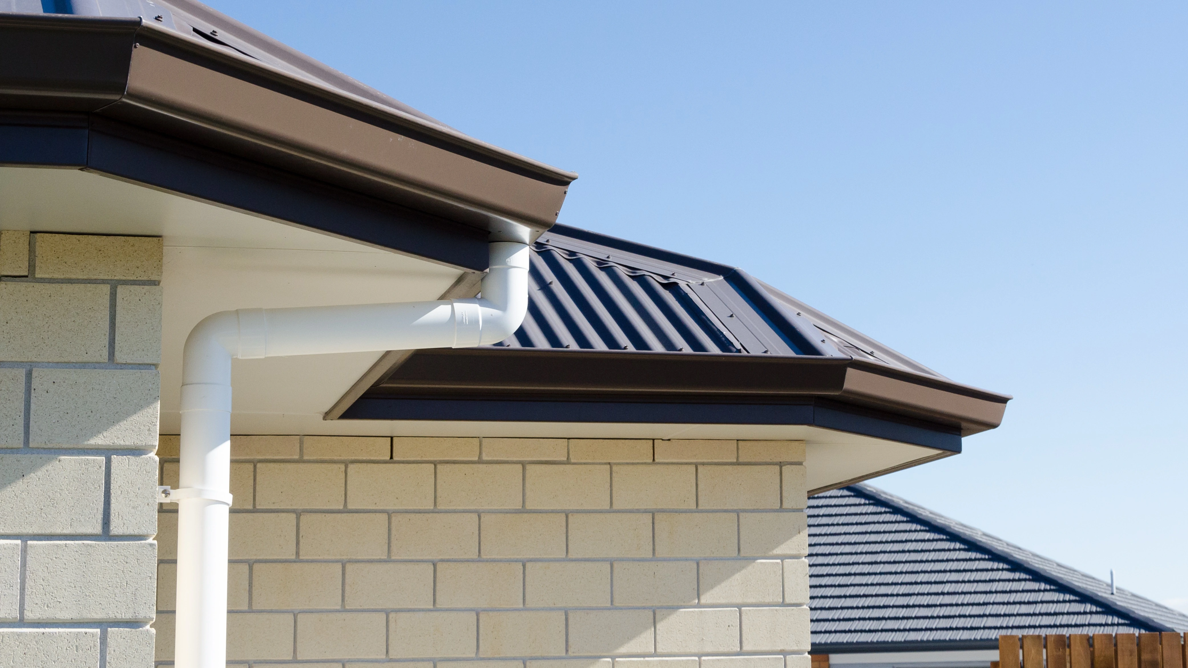 Downpipe of a house with a new brown roof